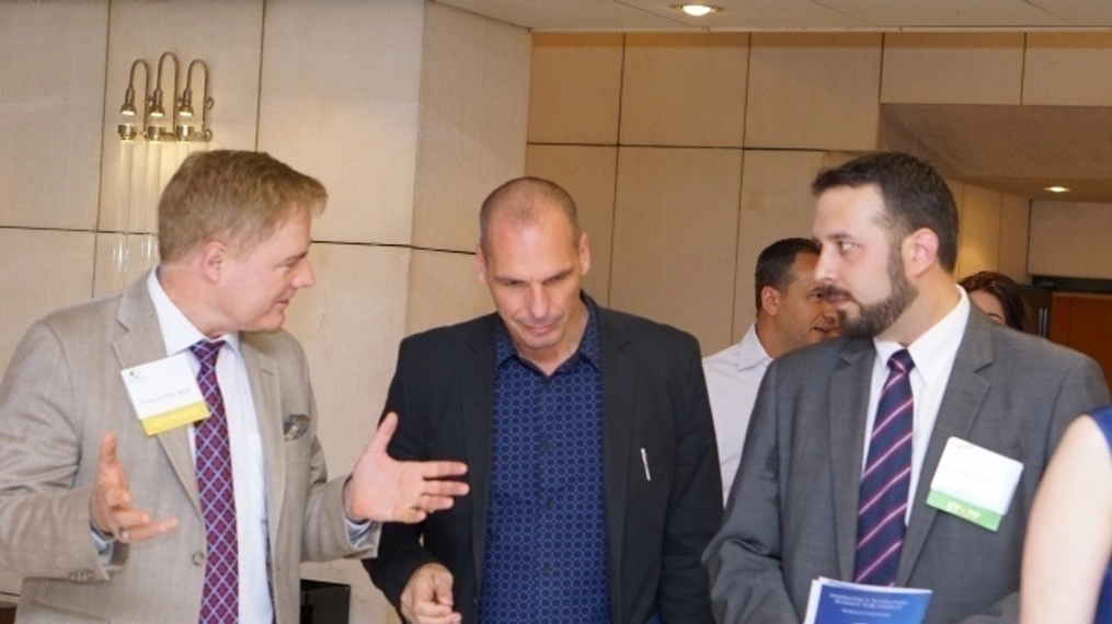 Dr palmer and Yanis Varoufakis walk while in discussion.